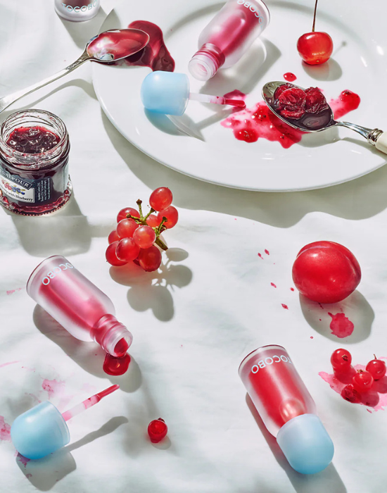 A woman applying serum with a dropper to her face for skincare routine.